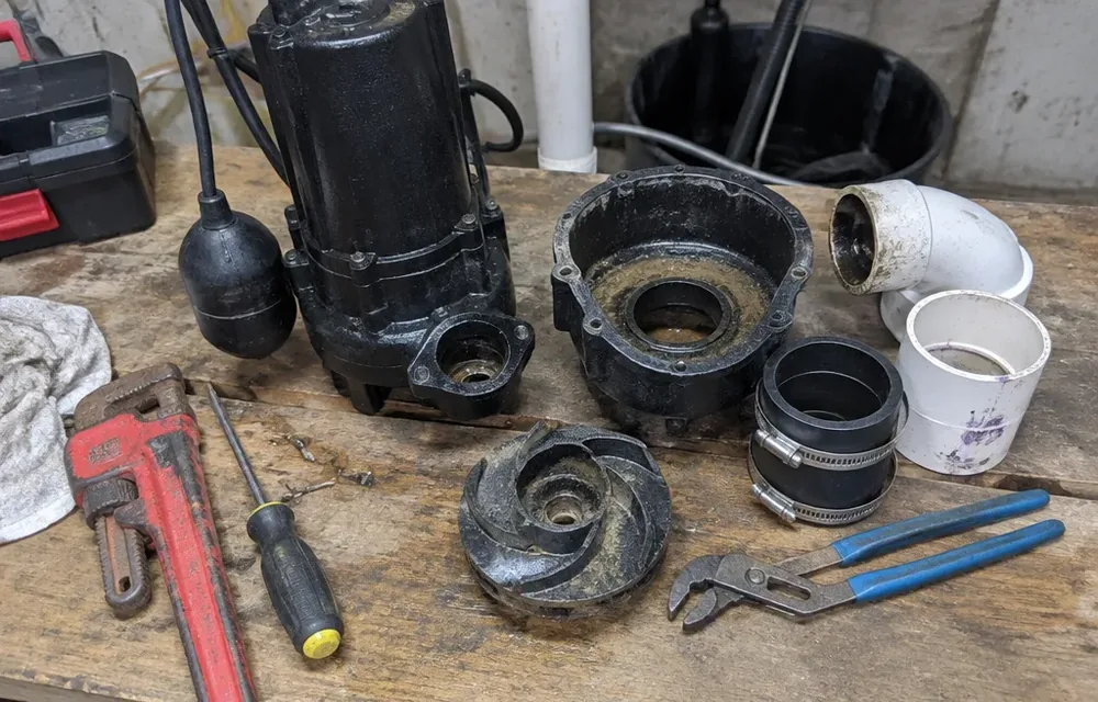 Close-up detail of sewage ejector pump parts and tools