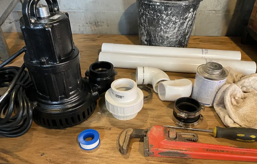 Close-up detail of sump pump installation parts and tools
